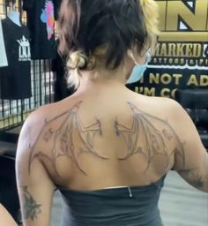 a woman with tattoos on her back and shoulder