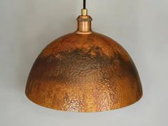 a copper colored light hanging from a ceiling