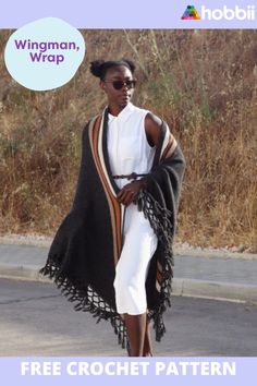 a woman walking down the street wearing a shawl