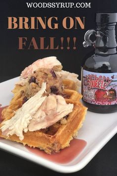 a plate with waffles and syrup on it next to a bottle of booze