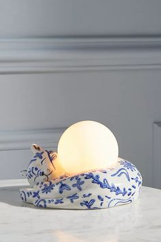 a blue and white lamp sitting on top of a table next to a stuffed animal