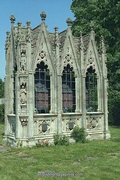 an old stone building sitting in the middle of a green field with trees behind it