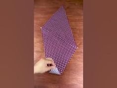 a person is tying a purple tie on the floor