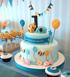 a blue and white cake with balloons on it's top is the number one