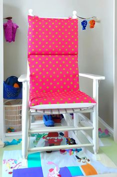 a child's rocking chair with pink and yellow polka dots on the seat cover