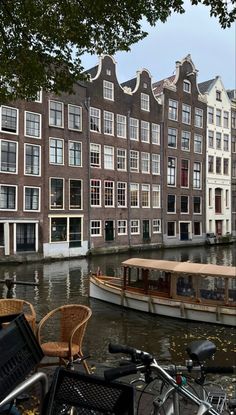 there is a boat in the water next to some buildings with bicycles parked near it