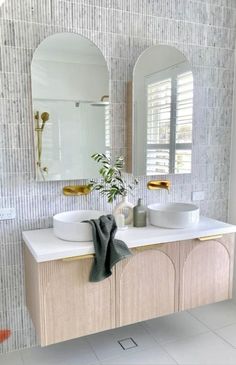 a bathroom with two sinks and mirrors in it