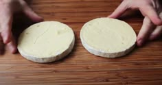 two pieces of cheese sitting on top of a wooden table