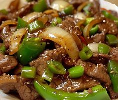 beef and peppers with sesame seeds in a white bowl