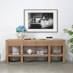 a living room scene with focus on the coffee table and vase filled with blue flowers