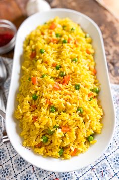 a white dish filled with rice and vegetables