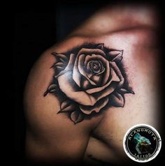 a black and white rose tattoo on the shoulder