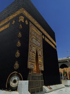 a large black building with gold designs on it's sides and an open doorway