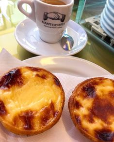 two pastries on a plate next to a cup of coffee