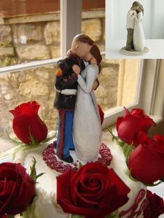 a wedding cake decorated with red roses and a bride and groom figurine