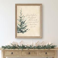 a christmas mantle with candles and greenery on it in front of a framed art piece