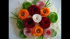 an arrangement of flowers arranged on top of each other in a circular arrangement with green leaves