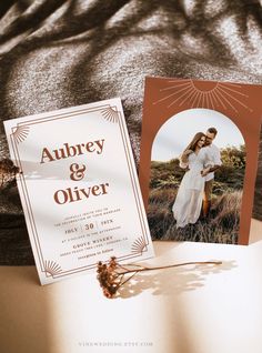 an open book on a bed next to a couple's wedding card and flower