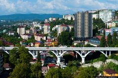 an aerial view of a city with tall buildings in the background and a bridge crossing over it