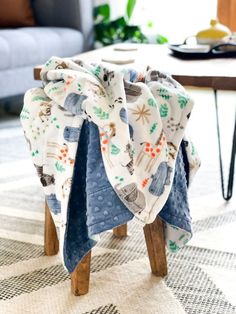 a small wooden stool with a blanket on it