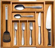 an open wooden drawer with utensils and spoons in it, including one fork