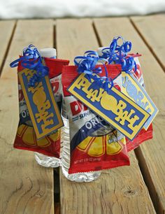 two bags of chips sitting on top of a wooden table