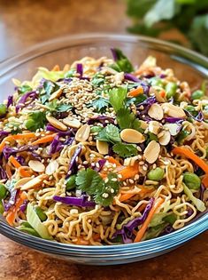 a glass bowl filled with noodles and vegetables