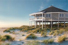 a house sitting on top of a sandy beach