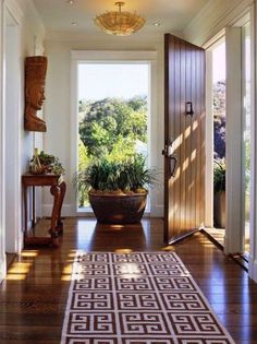 an entry way with a potted plant on the floor