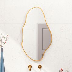 a bathroom with a sink, mirror and vase on the wall