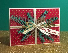 a handmade christmas card with a pine cone and ribbon on the front, decorated with polka dots