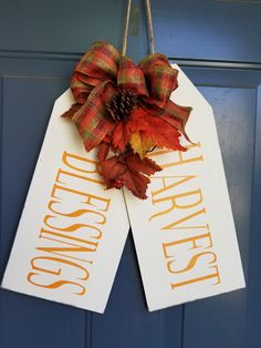 an autumn door hanger with the words happy thanksgiving written on it and a plaid bow