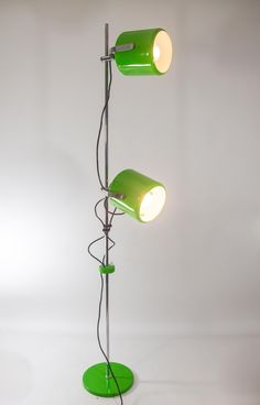 a green floor lamp with two lights on each side and one light on the other