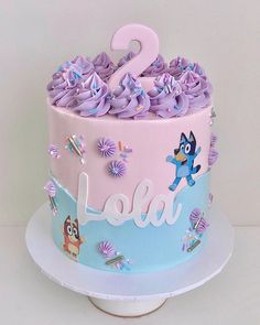 a two tiered cake with purple frosting and decorations on the top is decorated with cartoon characters