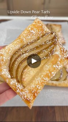 a person holding up a piece of apple tarts