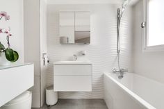 a white bathroom with a sink, toilet and bathtub