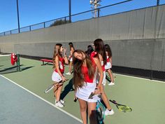 a group of young women standing on top of a tennis court