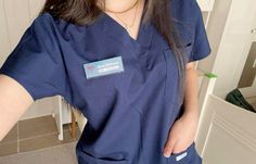 a woman in scrubs is standing with her hands on her hips