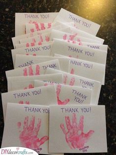 thank you cards with handprints on them sitting on a counter top next to a cell phone