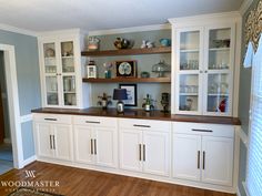 an empty kitchen with white cabinets and wood flooring in the center is seen here