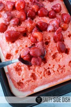 a square cake with strawberries on top in a pan