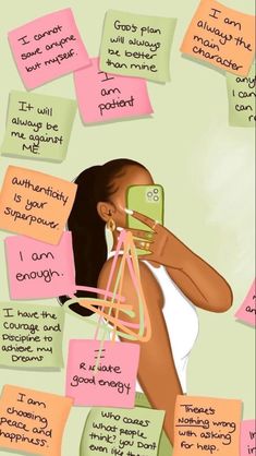 a woman holding a cell phone in front of sticky notes with words written on them