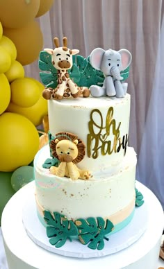 a three tiered cake with an elephant, giraffe and monkey topper