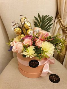 a flower pot with flowers and chocolates in it