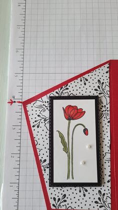 a close up of a piece of paper with a flower on it next to a ruler