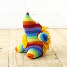 a colorful stuffed animal sitting on top of a wooden floor