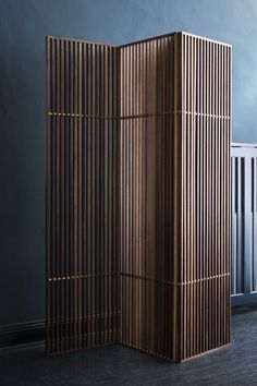 a room divider made out of wood in front of a blue wall and radiator