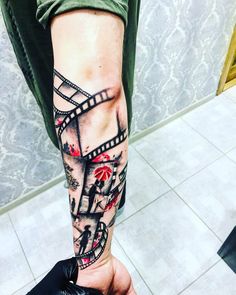 a man's arm with a film strip tattoo on it