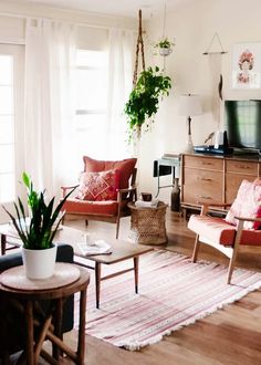 a living room filled with furniture and a flat screen tv on top of a wooden stand