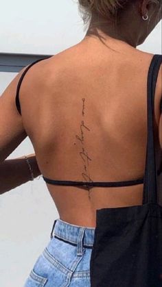 the back of a woman's body with writing on her lower back and upper back